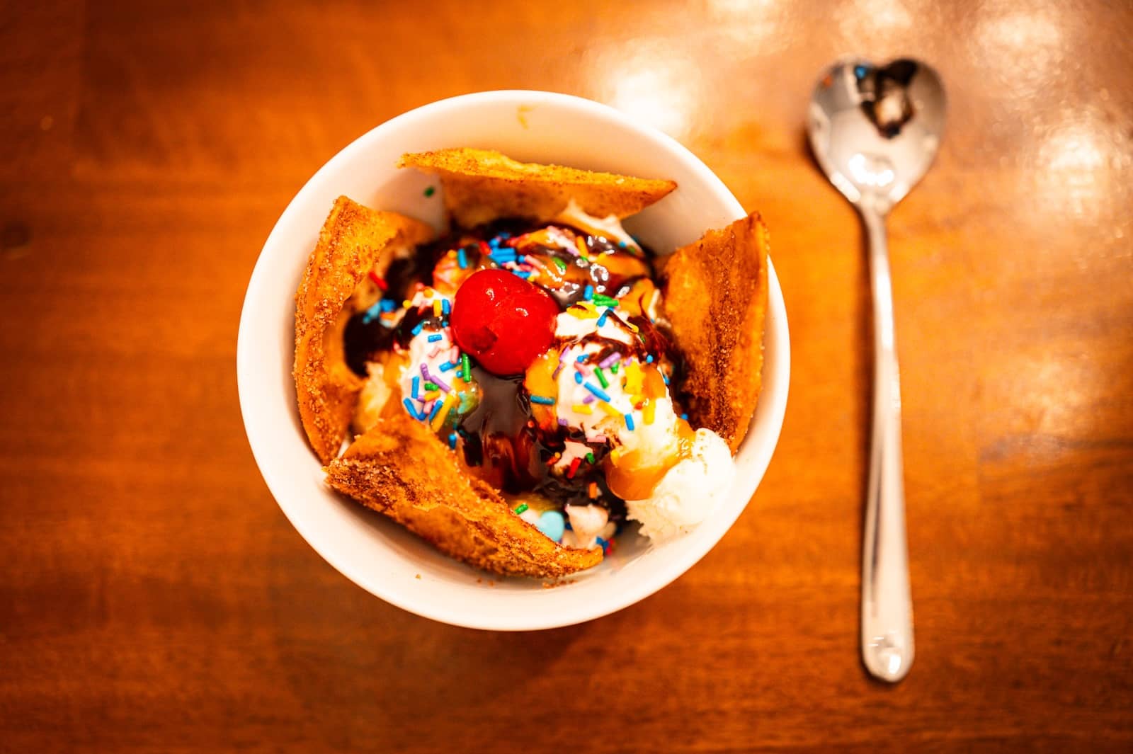 Image of homemade sweet nachos with Girls Churro Chips, ice cream, chocolate, sprinkles, and a heart shaped spoon